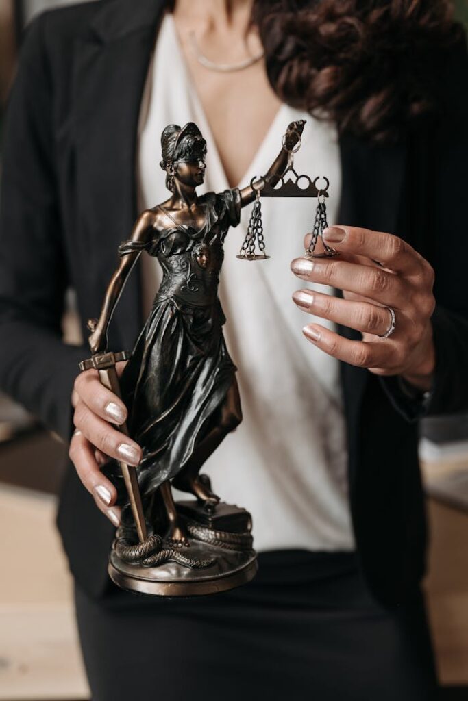 A Person Holding a Statuette of Lady Justice